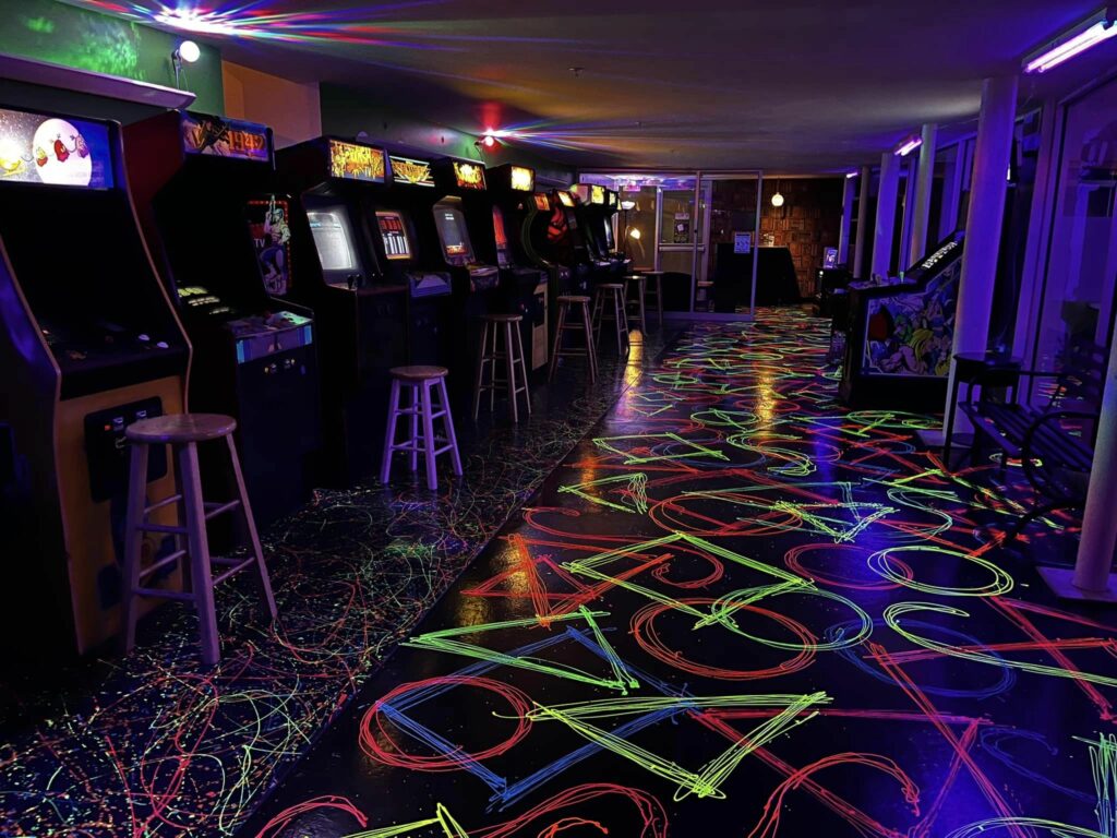 A wall of vintage arcade games at 1984 Arcade.